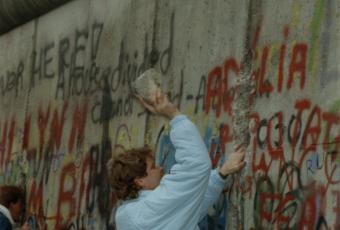 This Mauerspecht works with just a stone and his own strength, 12 November 1989 © Stadtmuseum Berlin | photo: Raimund Franke