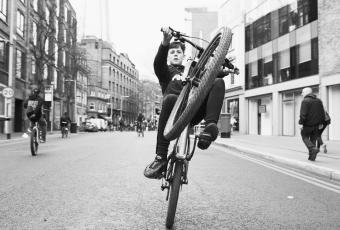 A boy rides the back wheel of his bike at the London Bikestormz