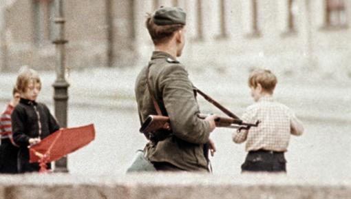 Photo of armed guard and playing children at the newly built Berlin Wall, 1961